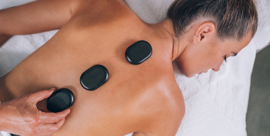 Frau bei einer Hot Stone Massage im Thermal Römerbad in Bad Kleinkirchheim