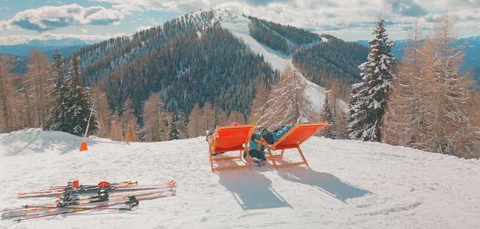 Sonnentankstellen im Skigebiet Bad Kleinkirchheim, Rote Liegestühle in verschneiter Winter-Landschaft in Kärnten