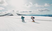 Pärchen beim Sonnenskilauf auf der Höhenabfahrt, Kärntens Top Skigebiet Bad Kleinkirchheim